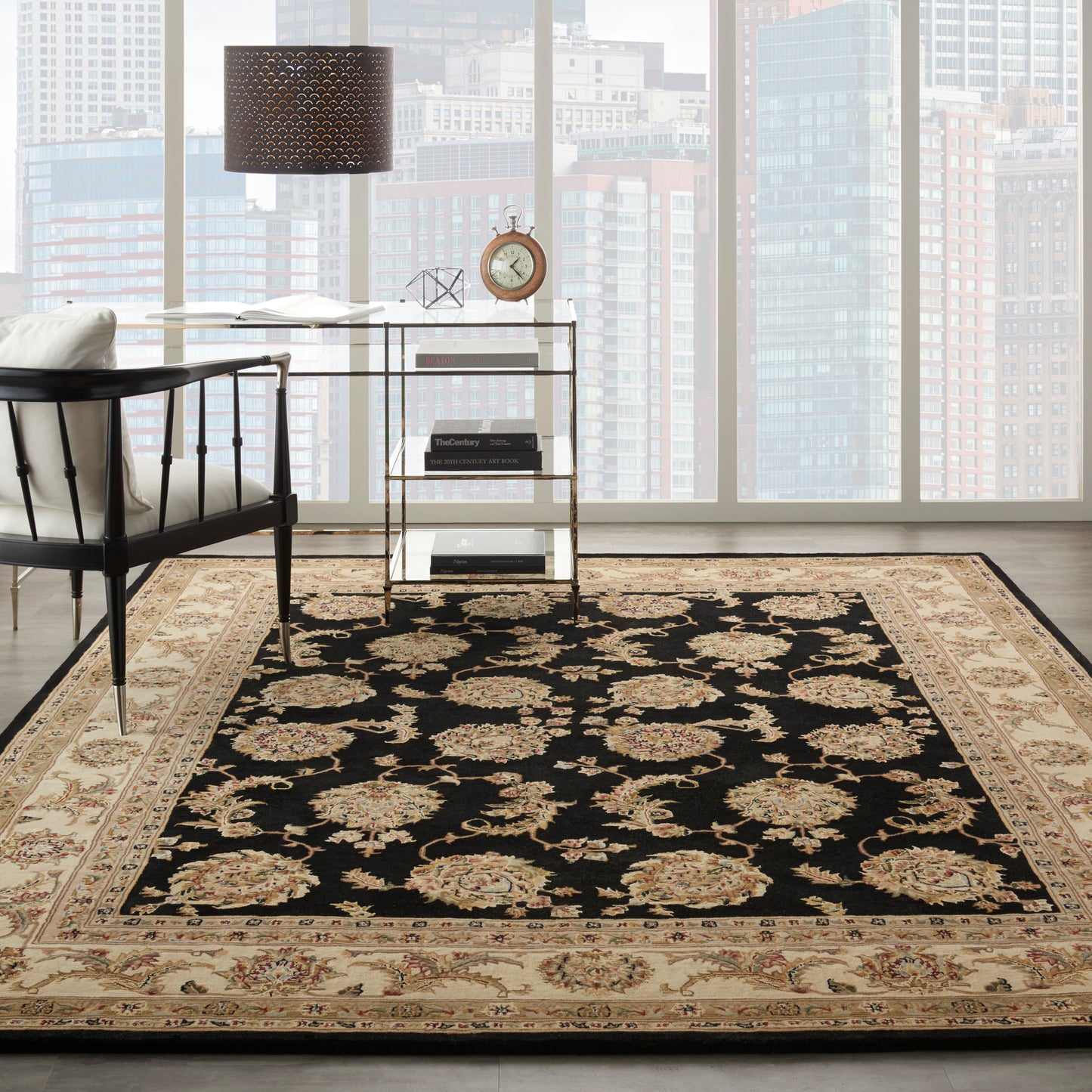 Rectangular Persian-style area rug with a black field, cream and gold floral medallions, and a beige border in a modern loft.