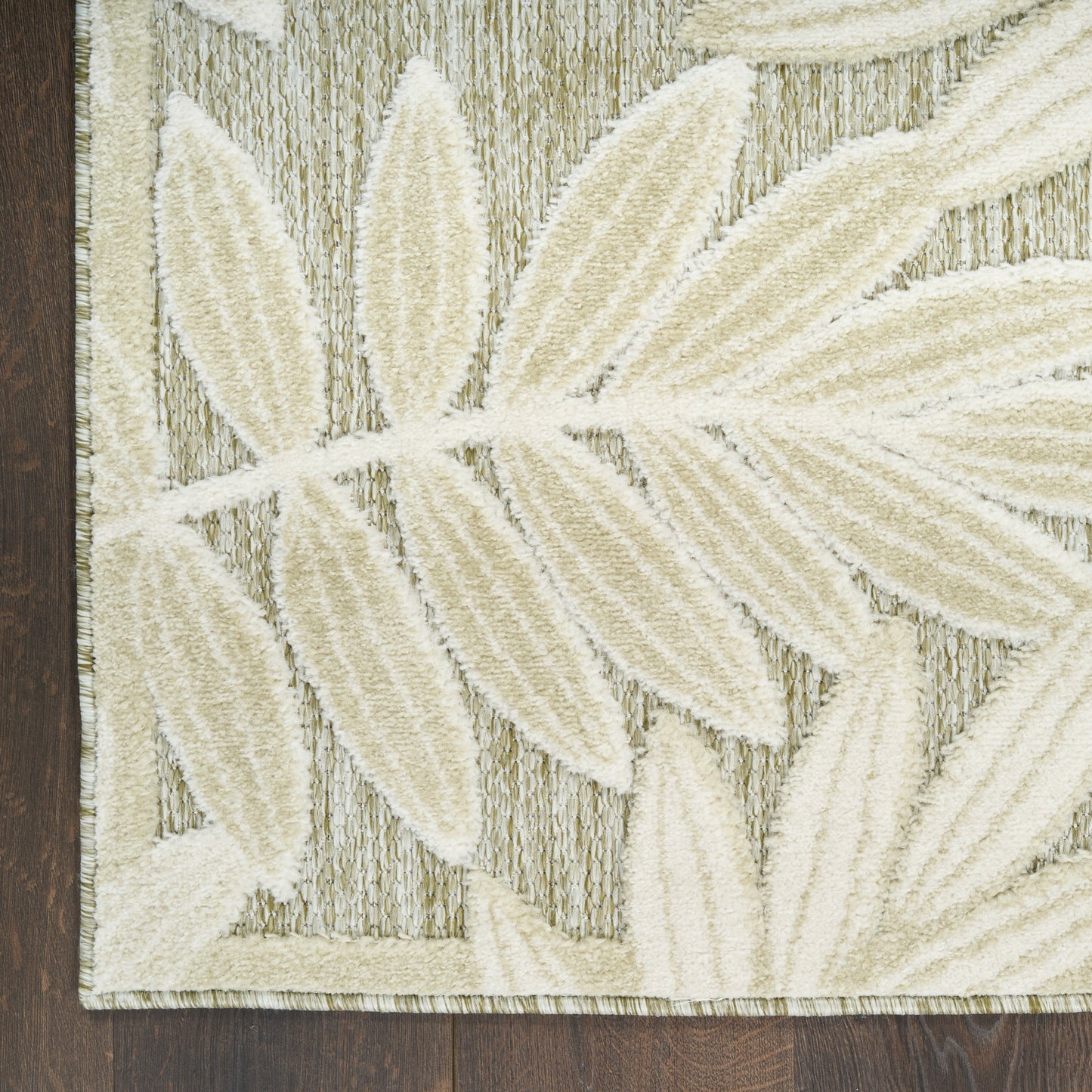 Neutral area rug featuring large cream botanical leaves on a textured gray-beige background; modern, contemporary style.