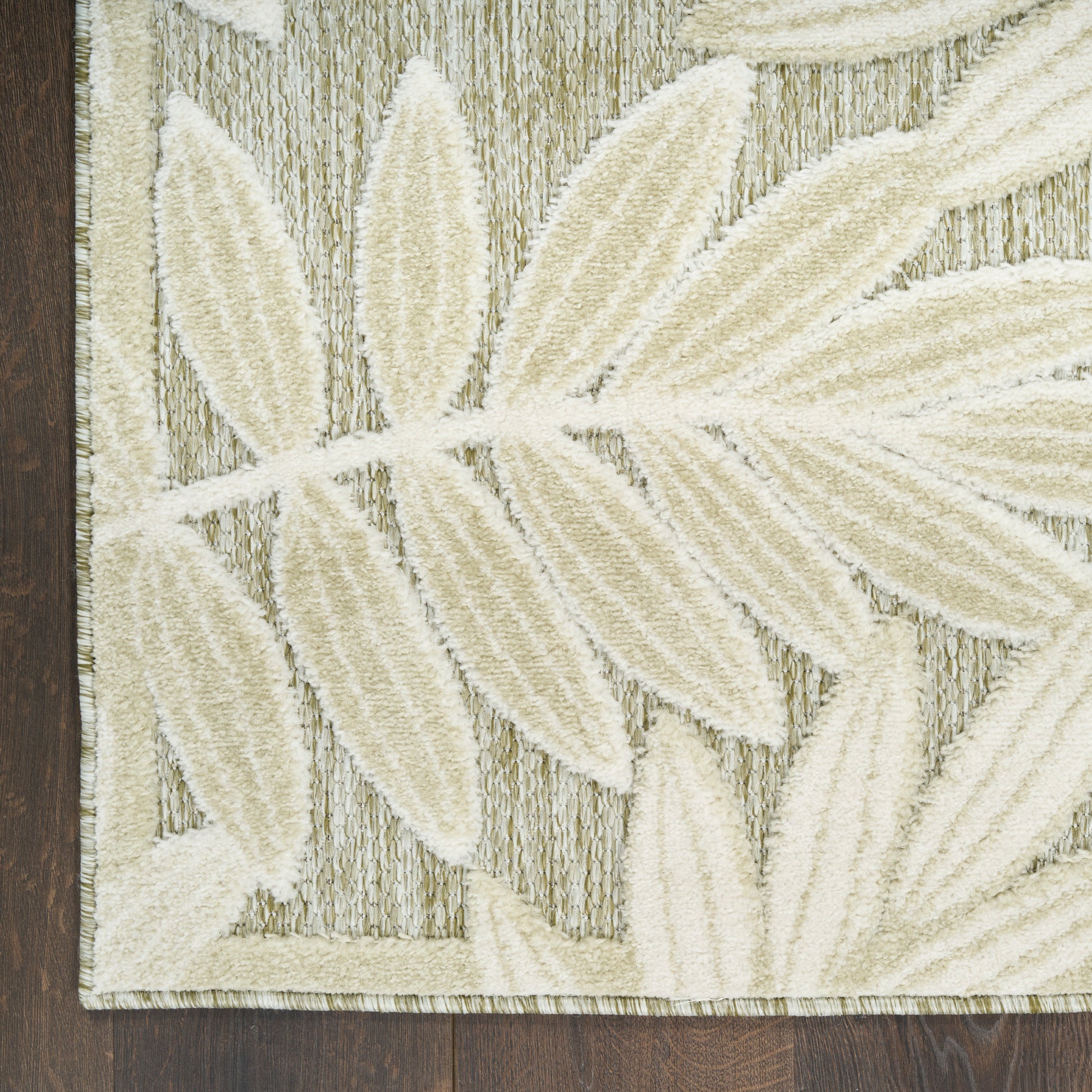 Neutral area rug featuring large cream botanical leaves on a textured gray-beige background; modern, contemporary style.