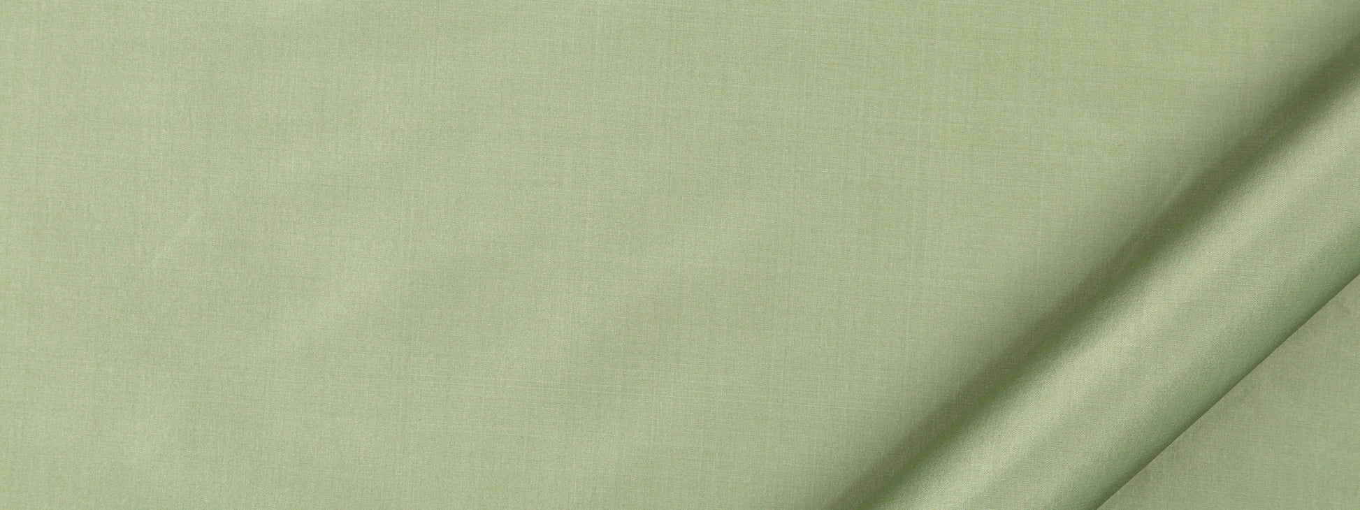 Close-up of pale sage green linen fabric with subtle weave texture and edge seam.