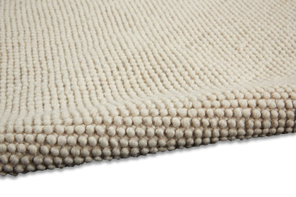 Beige textured rug with dense looped pile and beaded edge, plush and cozy.