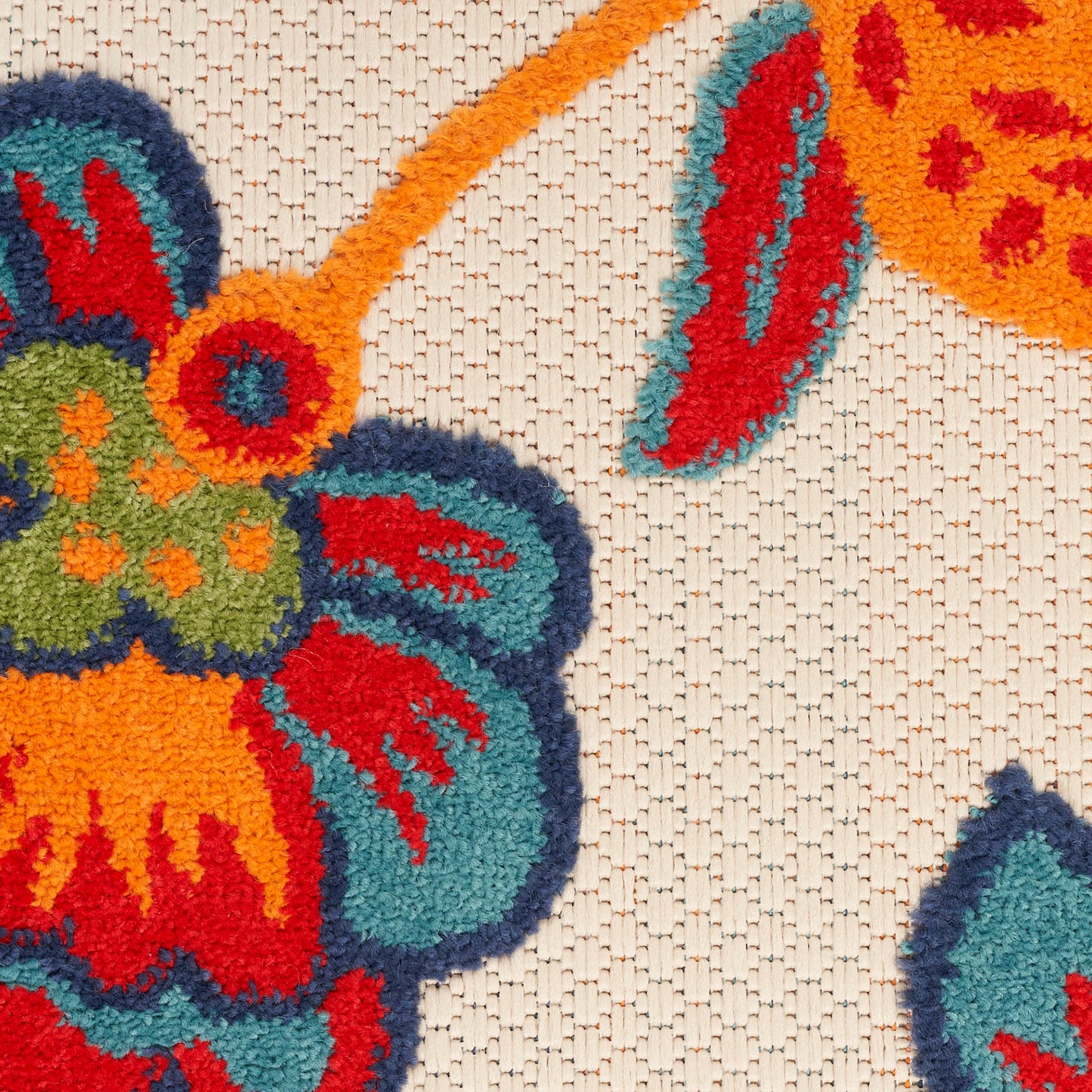 Vibrant floral rug with orange, teal, red petals on a beige woven background; boho-style decorative rug.