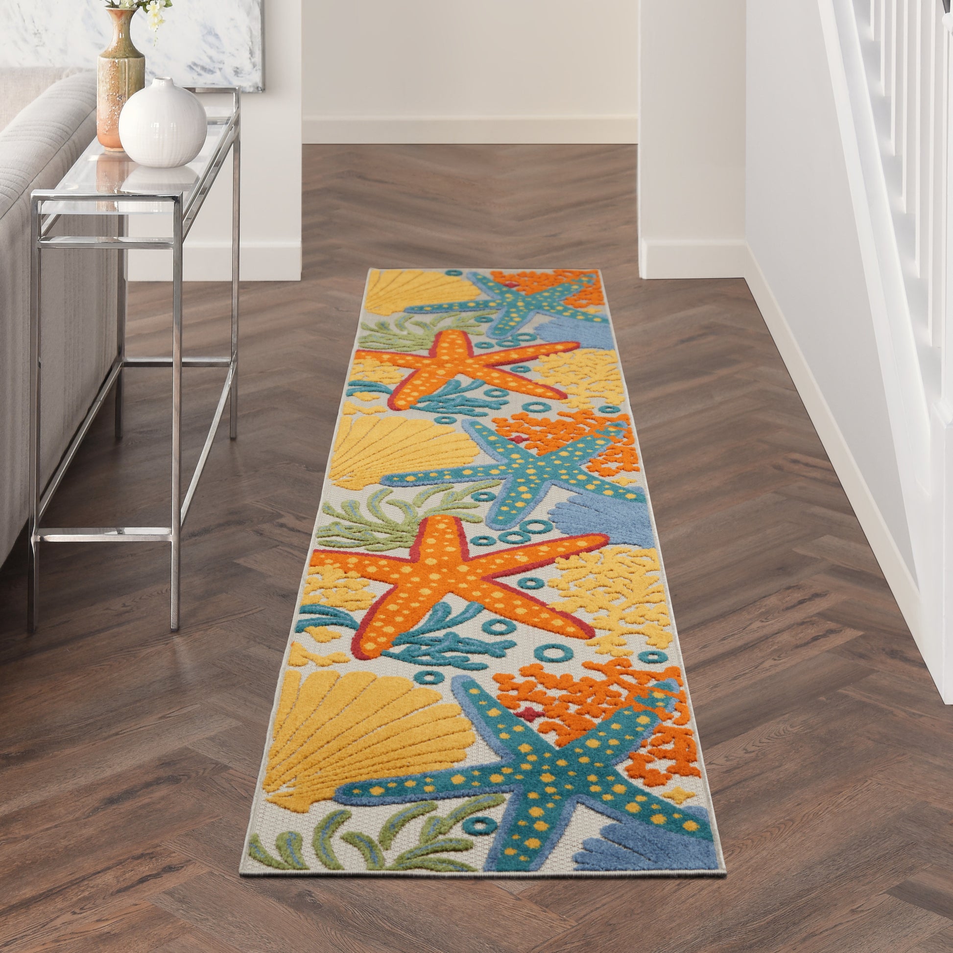 Vibrant beach-motif hallway runner rug with orange & blue starfish, seashells on yellow & aqua background.