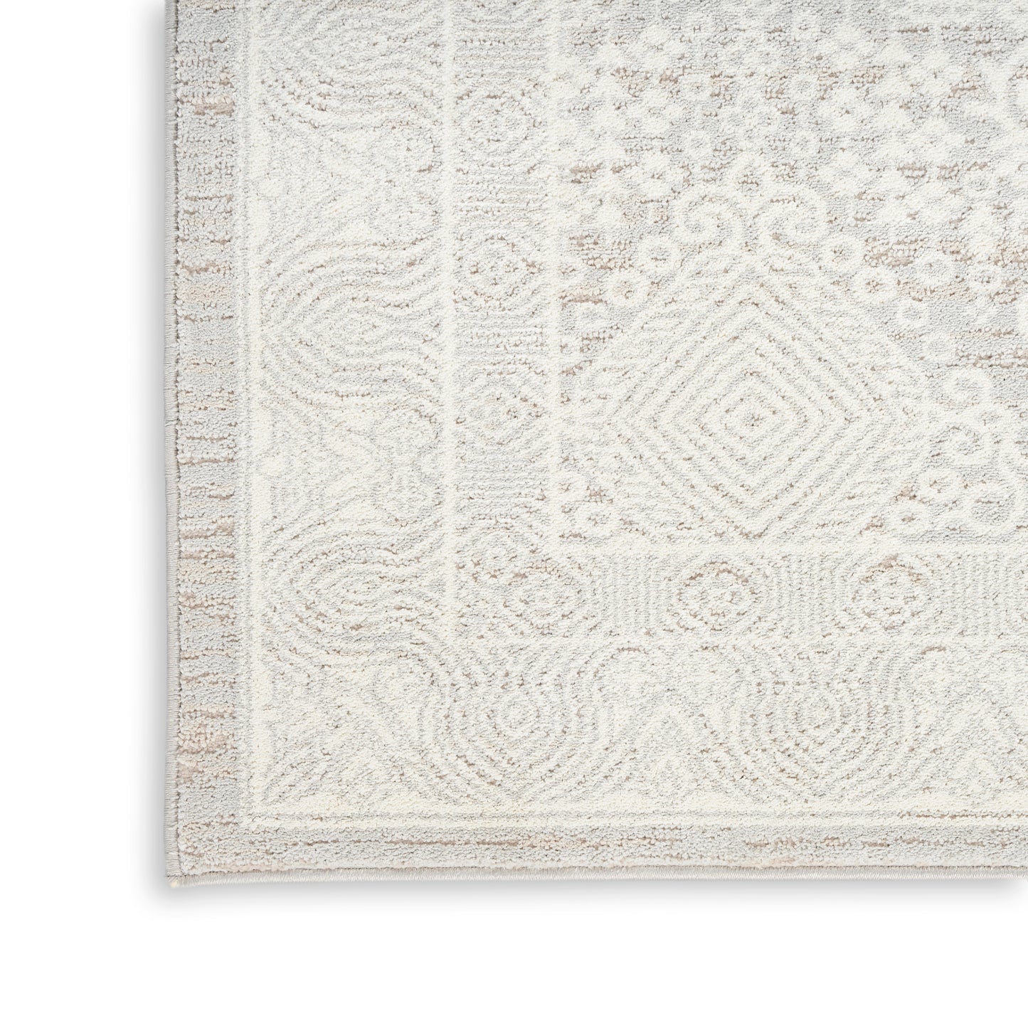 Cream-beige patterned area rug with ornate geometric motifs, bordered edge, plush woven texture for living space.