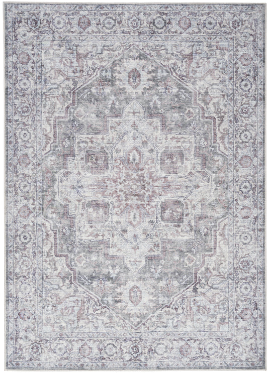 Distressed vintage Persian-style area rug with central medallion in gray-blue, ivory, and pink, ornate floral border.