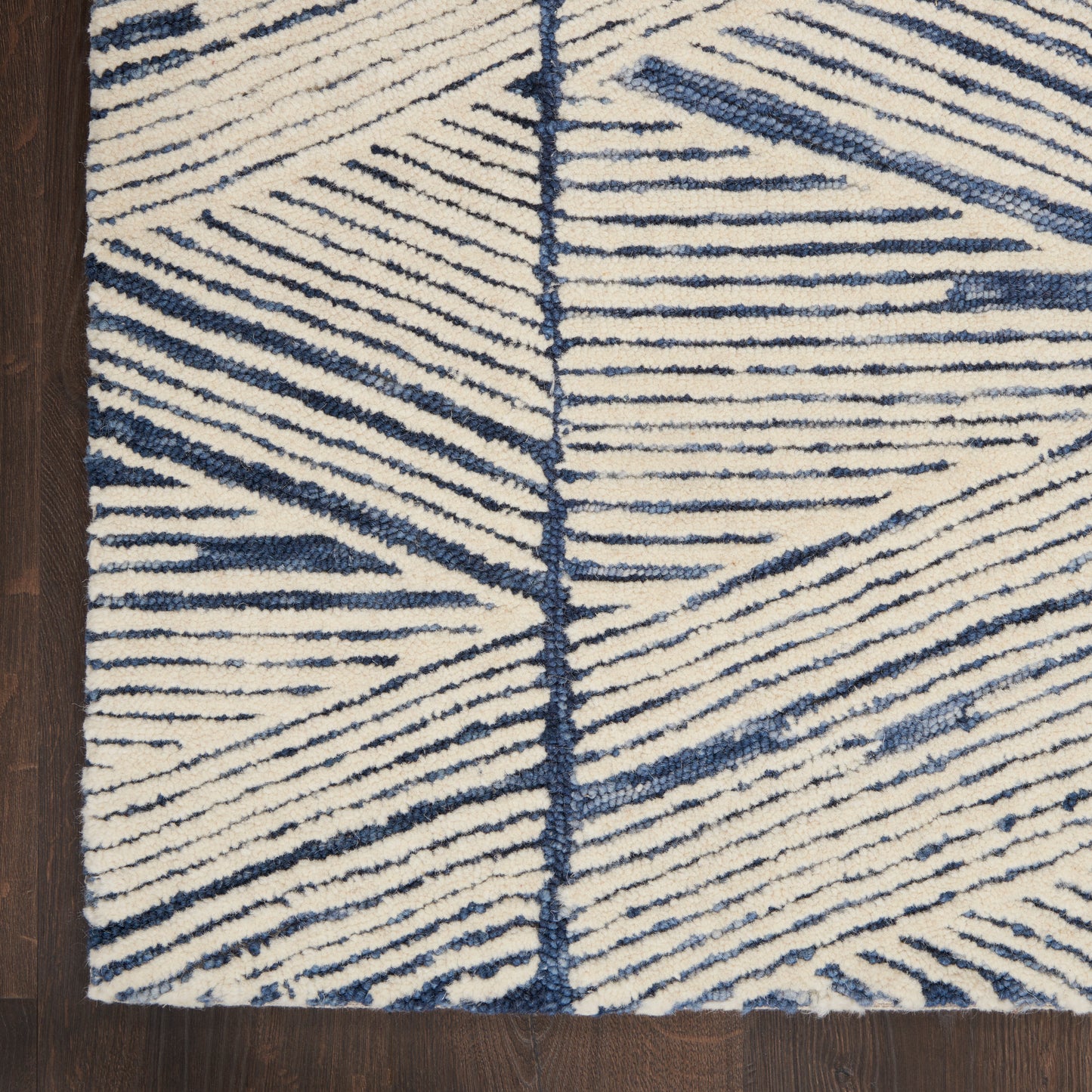 Cream and navy geometric 8 ft runner rug with bold blue linear patterns and plush tufted pile on dark wood floor.
