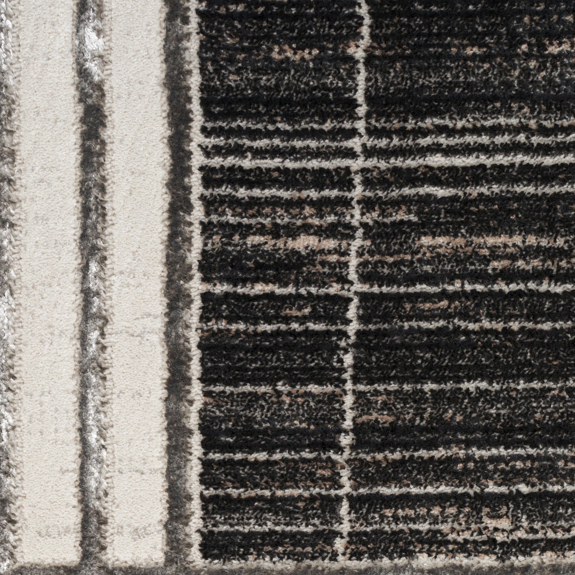 Close-up of a high-pile rug in black and beige with vertical beige stripes and a striped grid pattern.