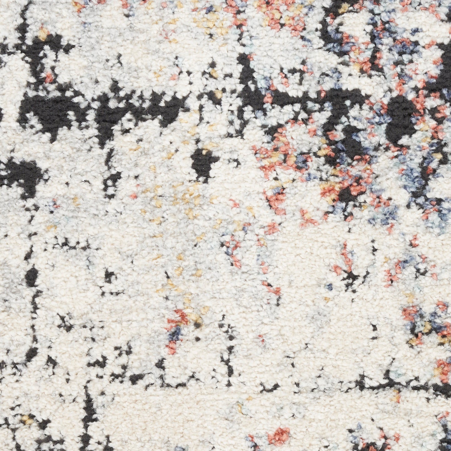 Soft cream abstract area rug with black, orange-pink and blue speckles; plush high-pile texture.
