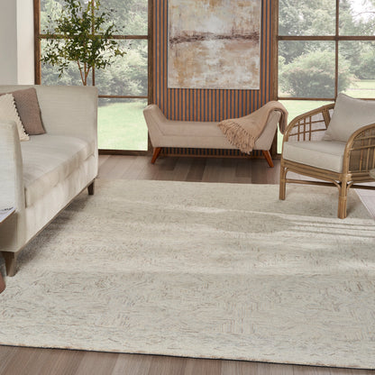 Soft cream shag rug on wood floor in a bright living room with a beige sofa, woven rattan chair, & warm wood accents.