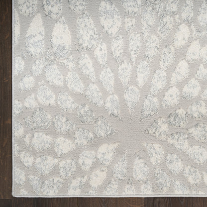Ivory and light gray tufted rug with a sunburst radiating petal pattern; soft, textured woven decor.
