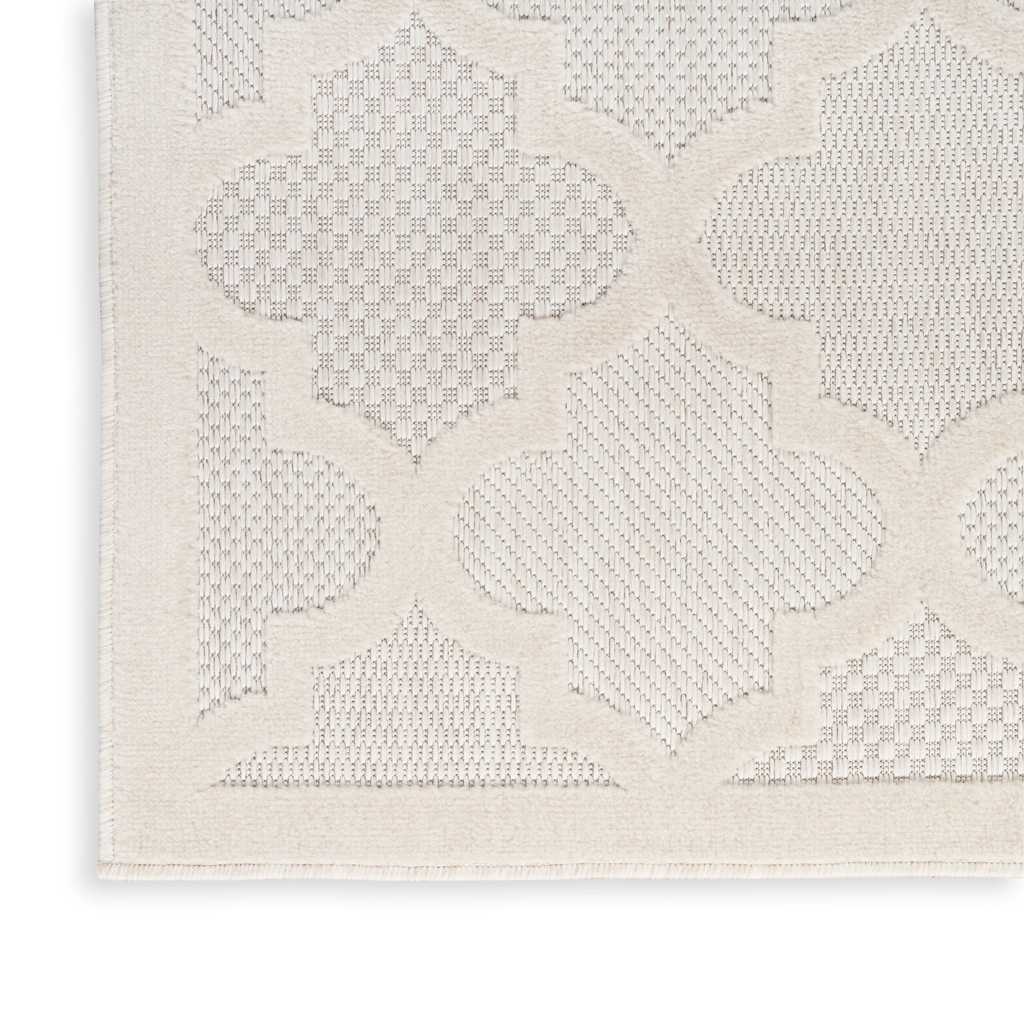 Cream textured rug with embossed quatrefoil lattice pattern and border; soft woven rectangle.
