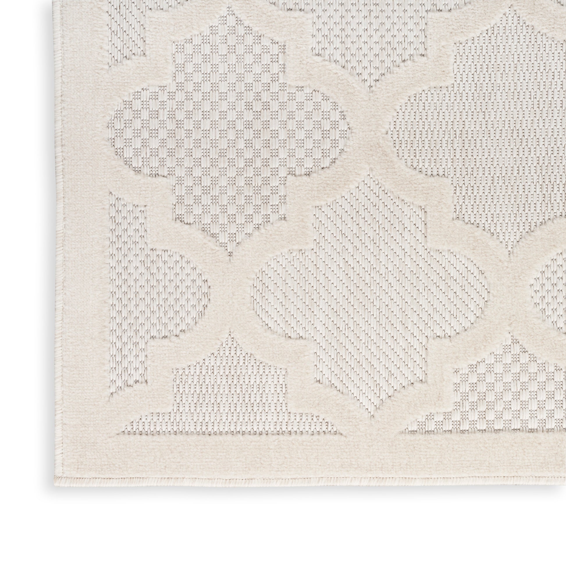 Cream textured rug with embossed quatrefoil lattice pattern and border; soft woven rectangle.