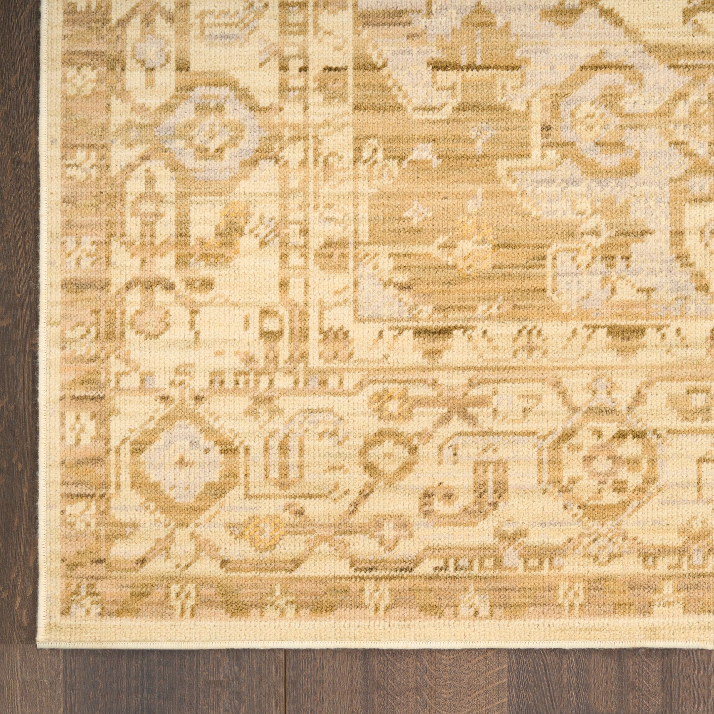 Beige oriental rug with ivory and tan geometric motifs, woven texture on dark wood floor