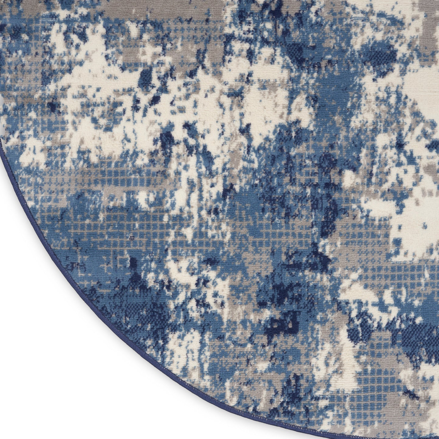 Abstract blue-gray and beige rug with distressed blotch pattern and curved edge.