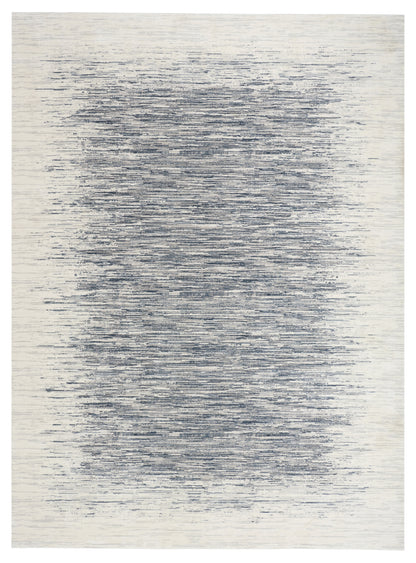 Beige rectangular rug with abstract blue-gray brush-stroke pattern and distressed, waterlike texture.