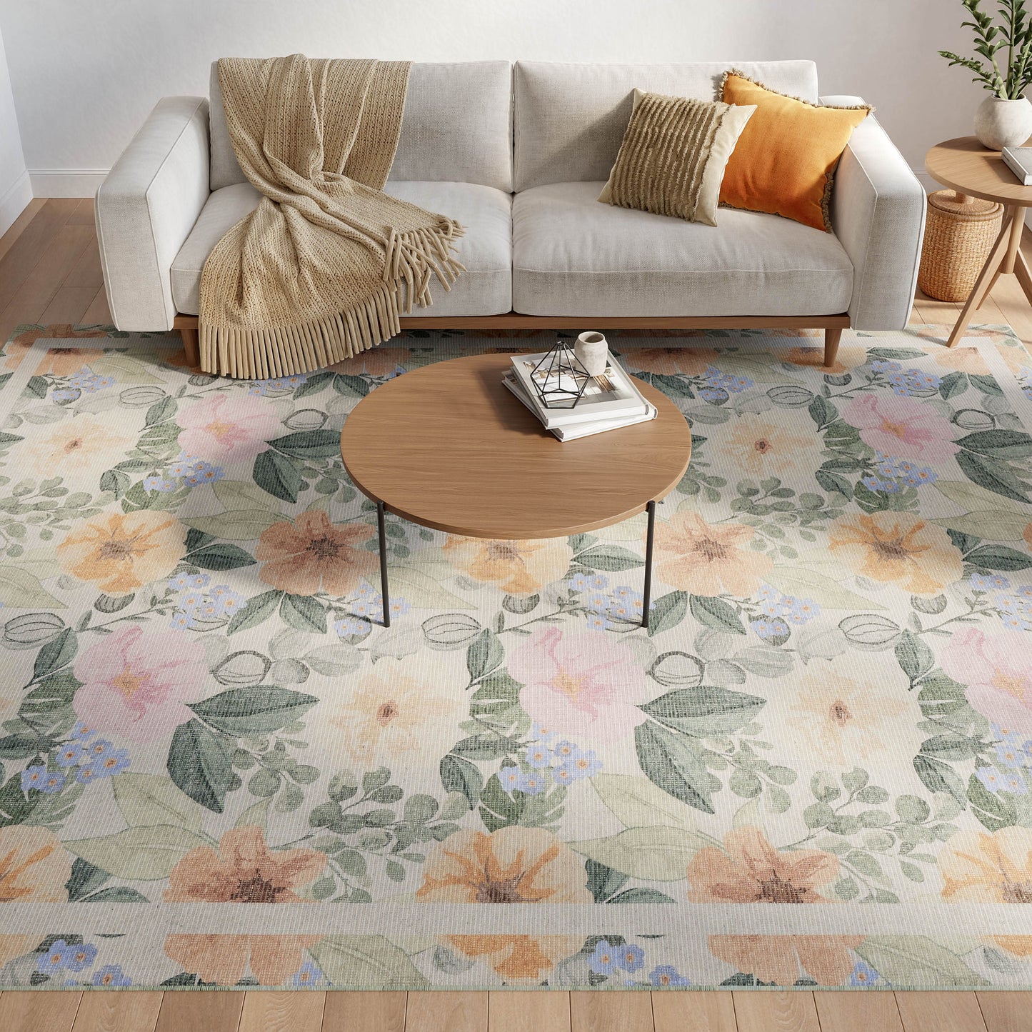 Living room with a light gray sofa, beige throw, orange and gold cushions, round wood coffee table, and pastel floral rug.
