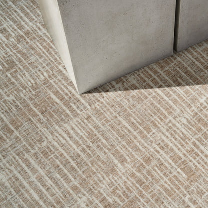 Grey concrete block corner on a beige textured rug with white linear pattern, modern minimalist decor.