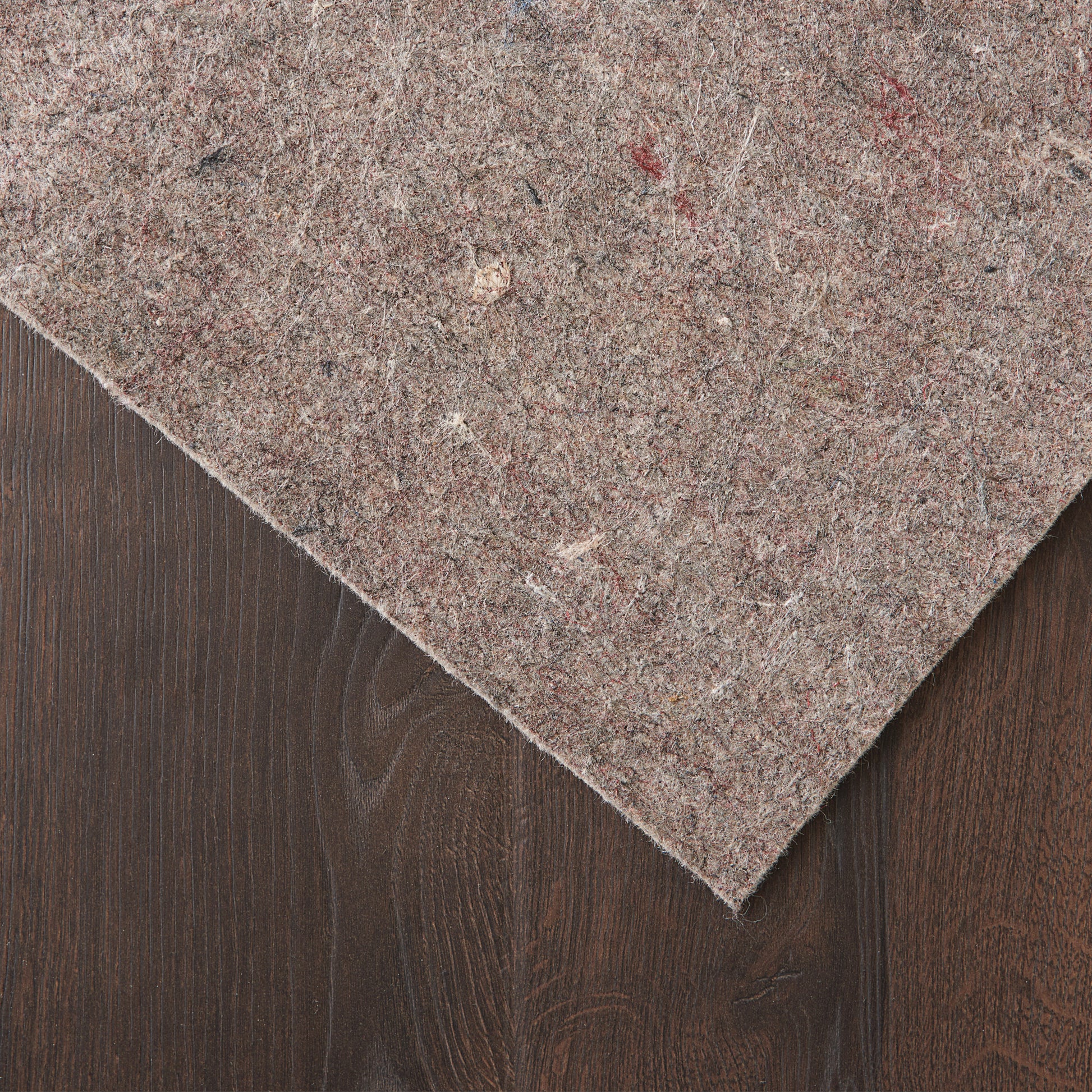 Brown speckled rug runner on dark wood surface; soft, textured fabric.