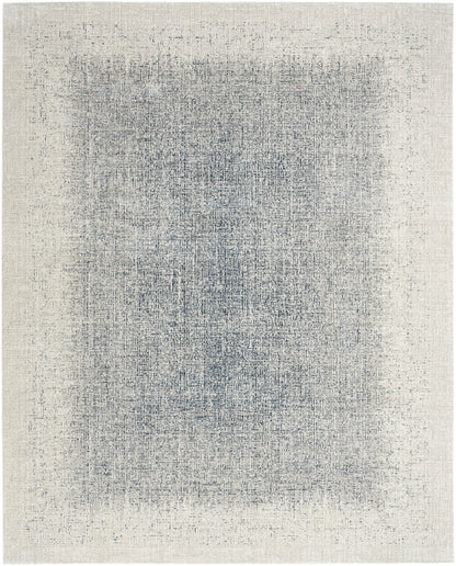 Rectangular woven area rug with a distressed blue-gray center on a cream-beige field; vintage abstract texture.