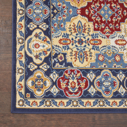 Corner view of a Bohemian area rug on a wooden floor, featuring blue, cream, red and gold floral motifs with a dark blue border.