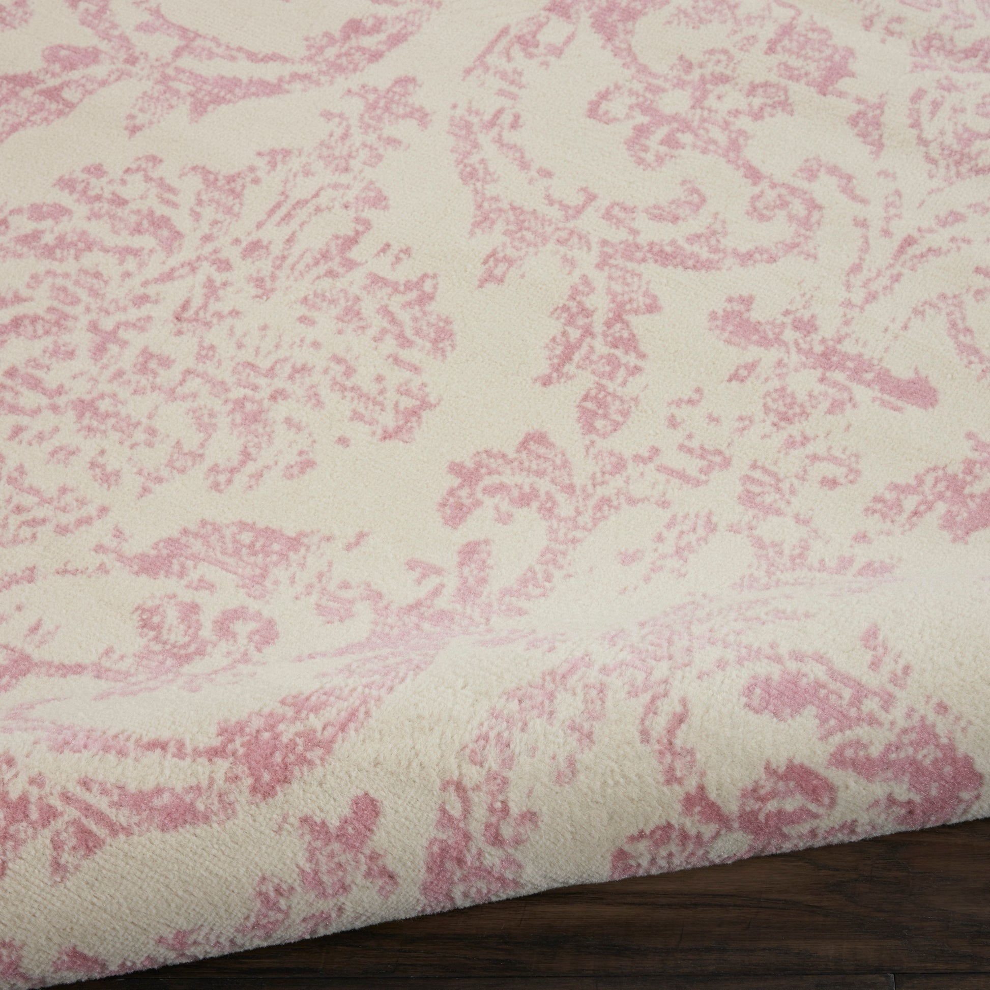 Cream rug with pink damask pattern, jacquard weave, folded edge.