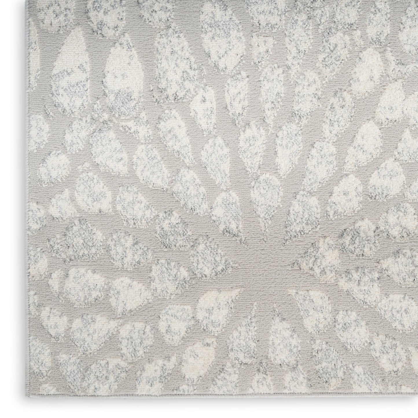 Light gray jacquard textile with a raised sunburst floral pattern and petal-like clusters.