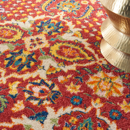 Vibrant red oriental rug with multicolor floral medallions in yellow, blue, green; plush pile, beside a brass pedestal.