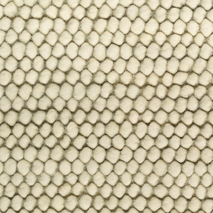 Close-up of cream-beige boucle fabric with tiny rounded tufted bumps, creating a plush textured surface.