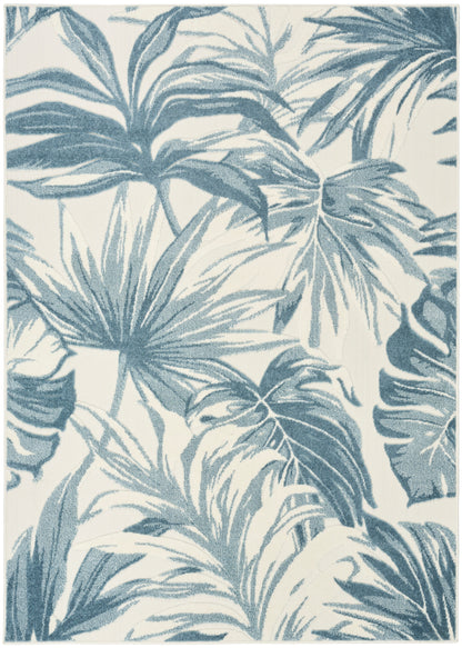 Blue palm leaf rug with teal-blue leaves on cream background; tropical woven textile.