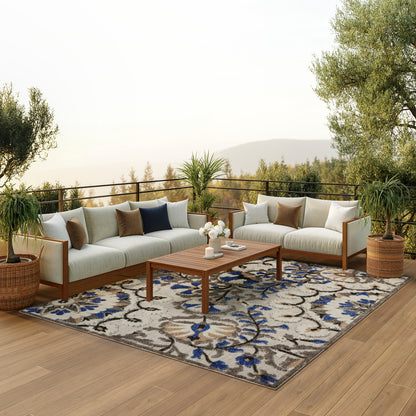 Outdoor sectional sofa set with beige cushions, wooden frame, blue and brown pillows, coffee table on patterned rug.