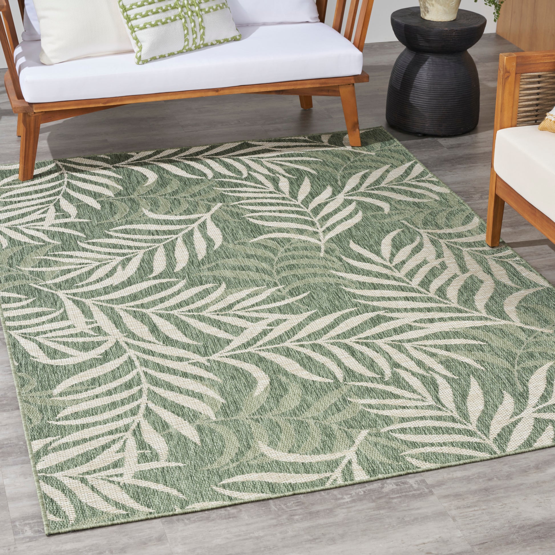 Green outdoor rug with a white palm-leaf pattern.