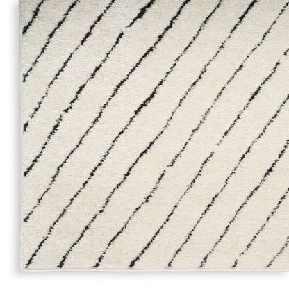 Cream shag rug with diagonal black lines, soft textured pile; rectangular area rug.