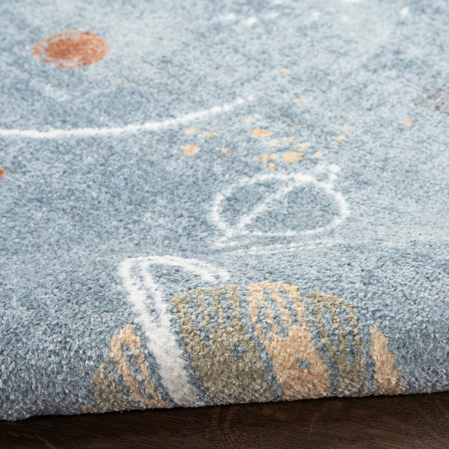 Blue-gray textured rug featuring chalk-white lines, beige shapes, and a small orange dot.