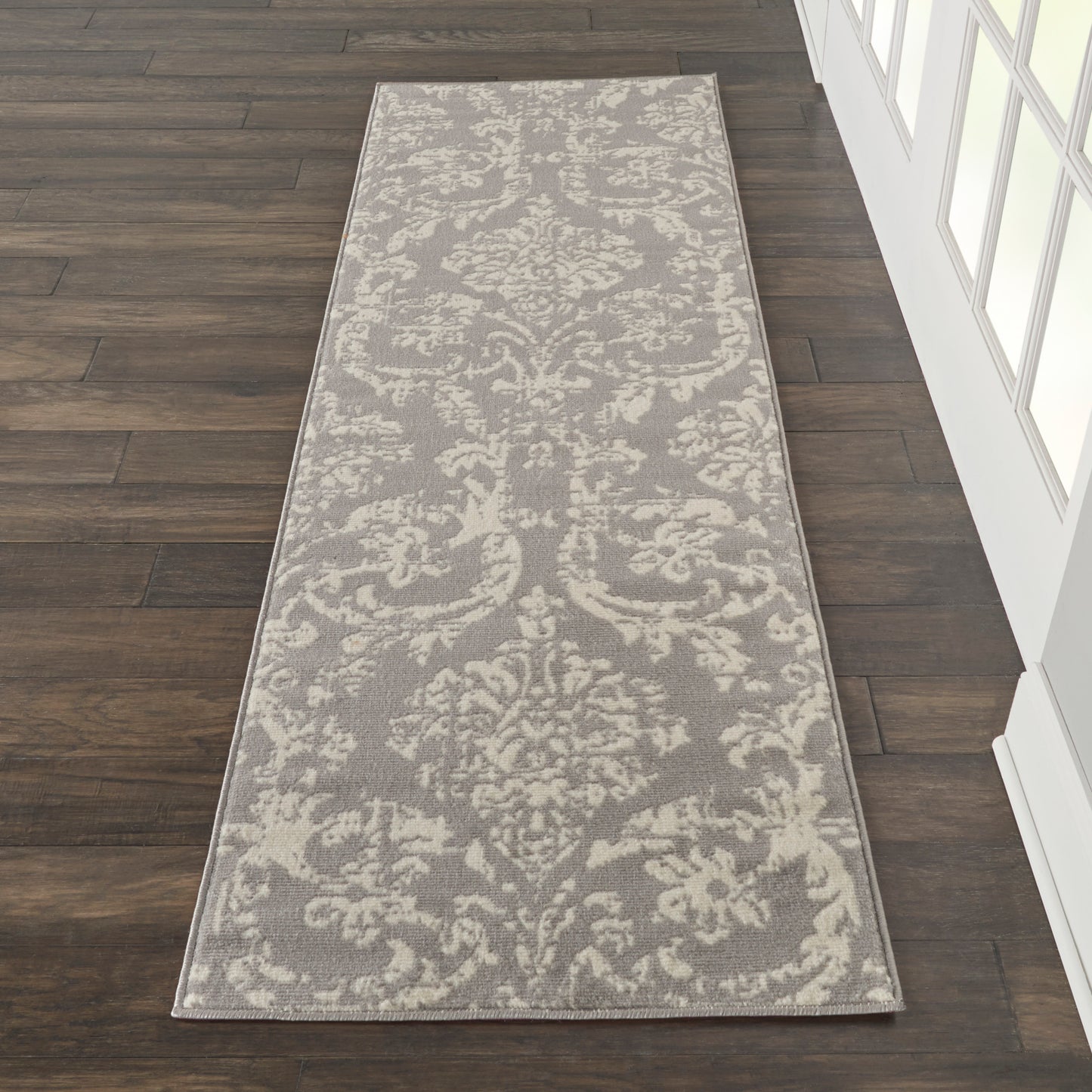 Gray runner rug with ivory damask pattern and pale border, ideal for a hallway.