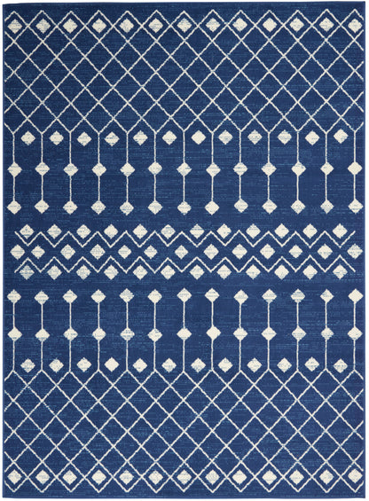 Navy blue rectangular rug with white diamond lattice and vertical line motifs in a geometric pattern.