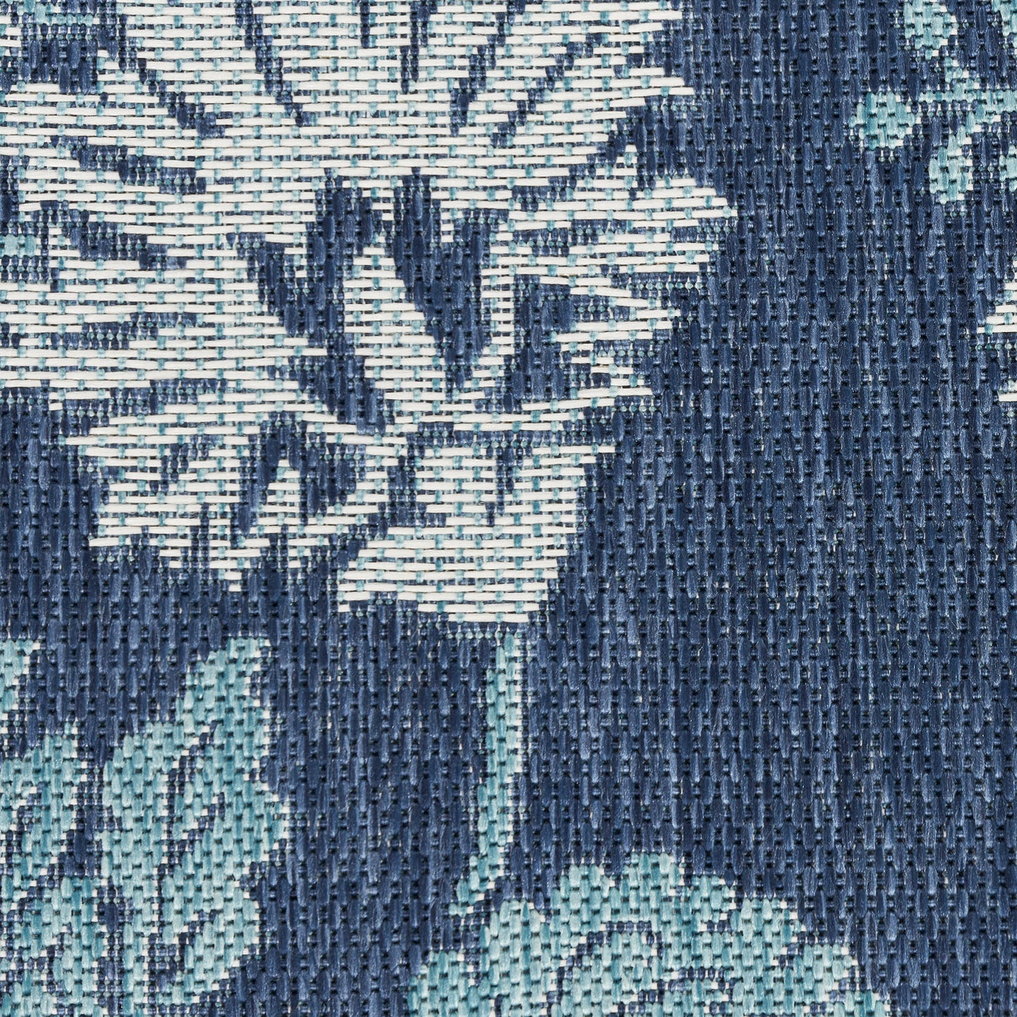 Close-up of navy blue woven jacquard fabric with light teal botanical floral pattern.