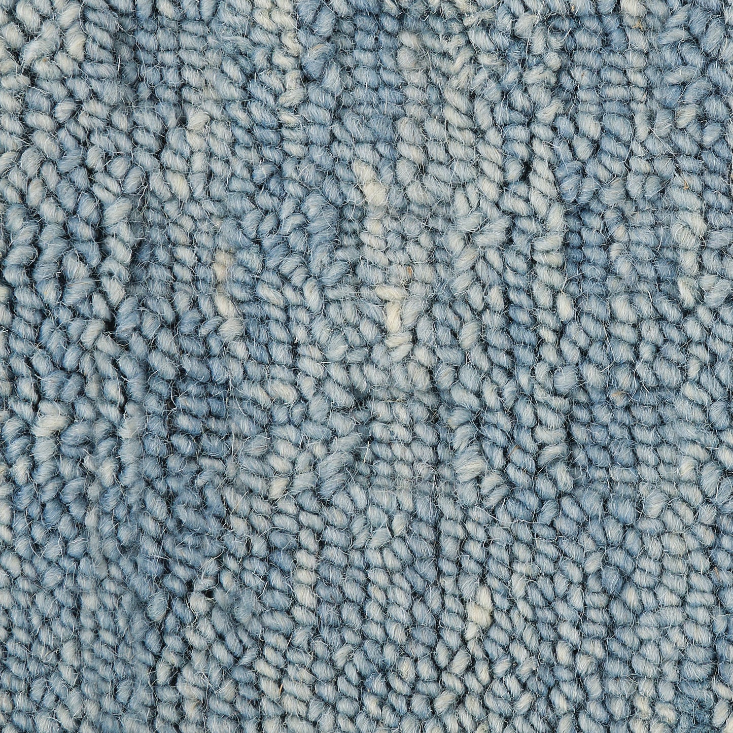 Blue boucle runner rug close-up showing soft loop pile with cream specks and varied blue tones.