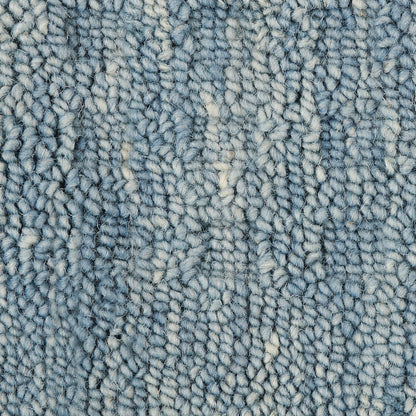 Blue boucle runner rug close-up showing soft loop pile with cream specks and varied blue tones.