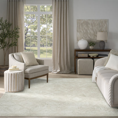 Neutral living room with beige fabric sofa and armchair, light textured rug, wooden furniture, and large window with beige curtains.