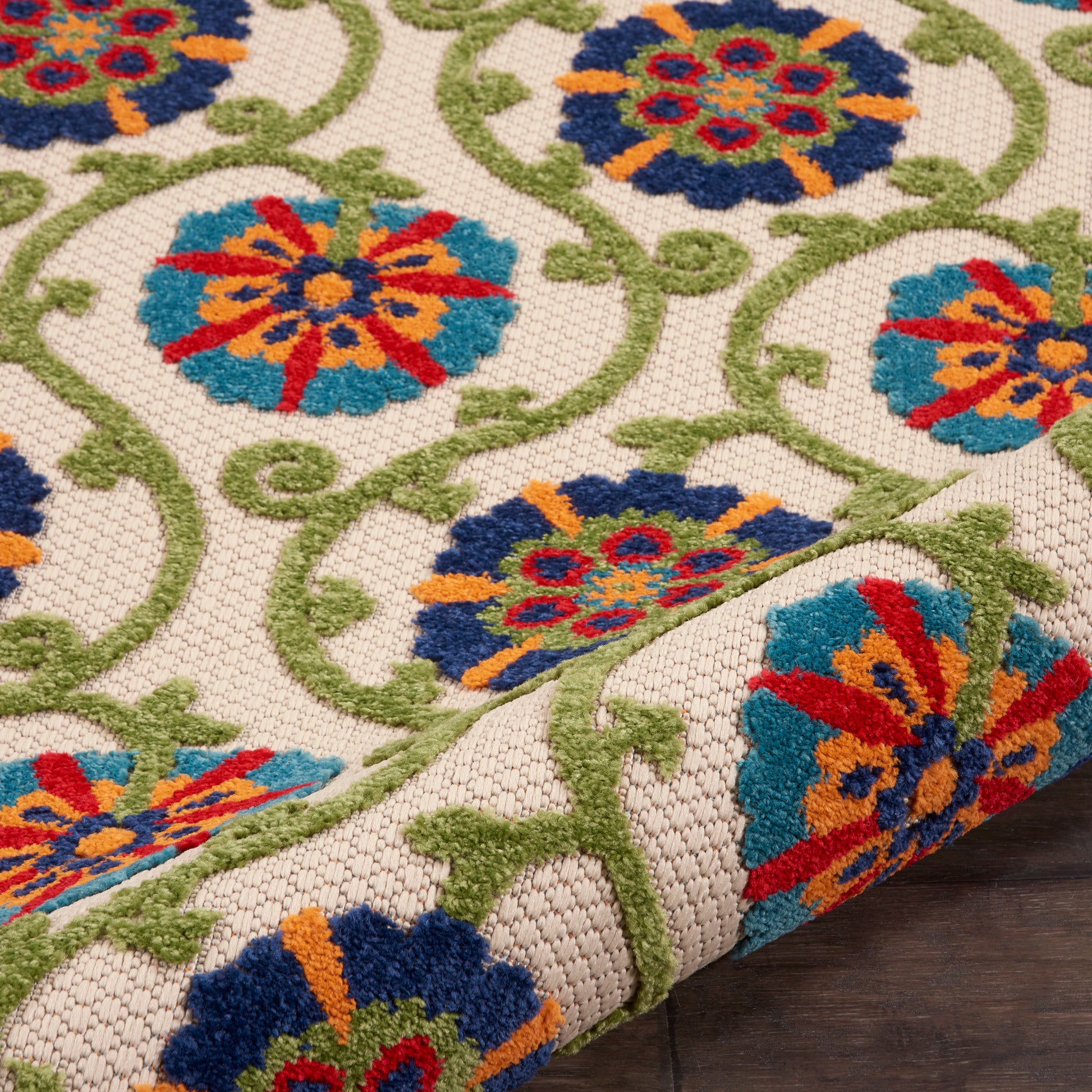 Colorful woven area rug with blue, teal, orange and red floral medallions on ivory background and green scrolling vines.