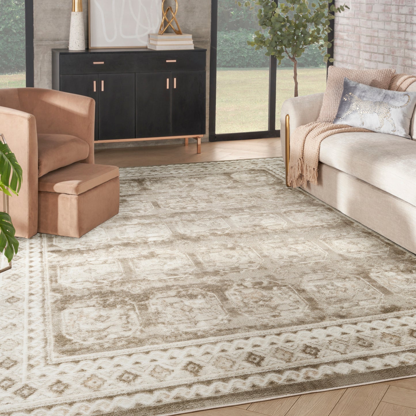 Neutral living room with beige sofa, peach armchair, cream-taupe oriental rug, black credenza, gold accents.