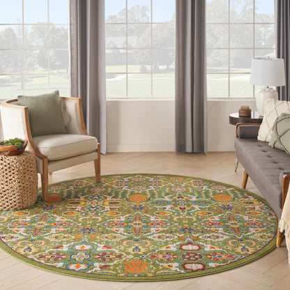 Round multicolor patterned area rug in a bright living room with beige armchair, gray sofa, and wicker side table.