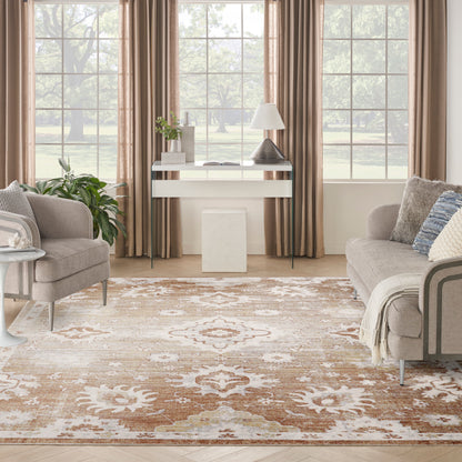 Cozy contemporary living room with two grey sofas, beige-brown rug, round glass coffee table, white console, lamp, plants by large windows.