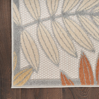 Textured woven rug with beige, gray and orange leaf motifs, bordered, on dark wood floor.