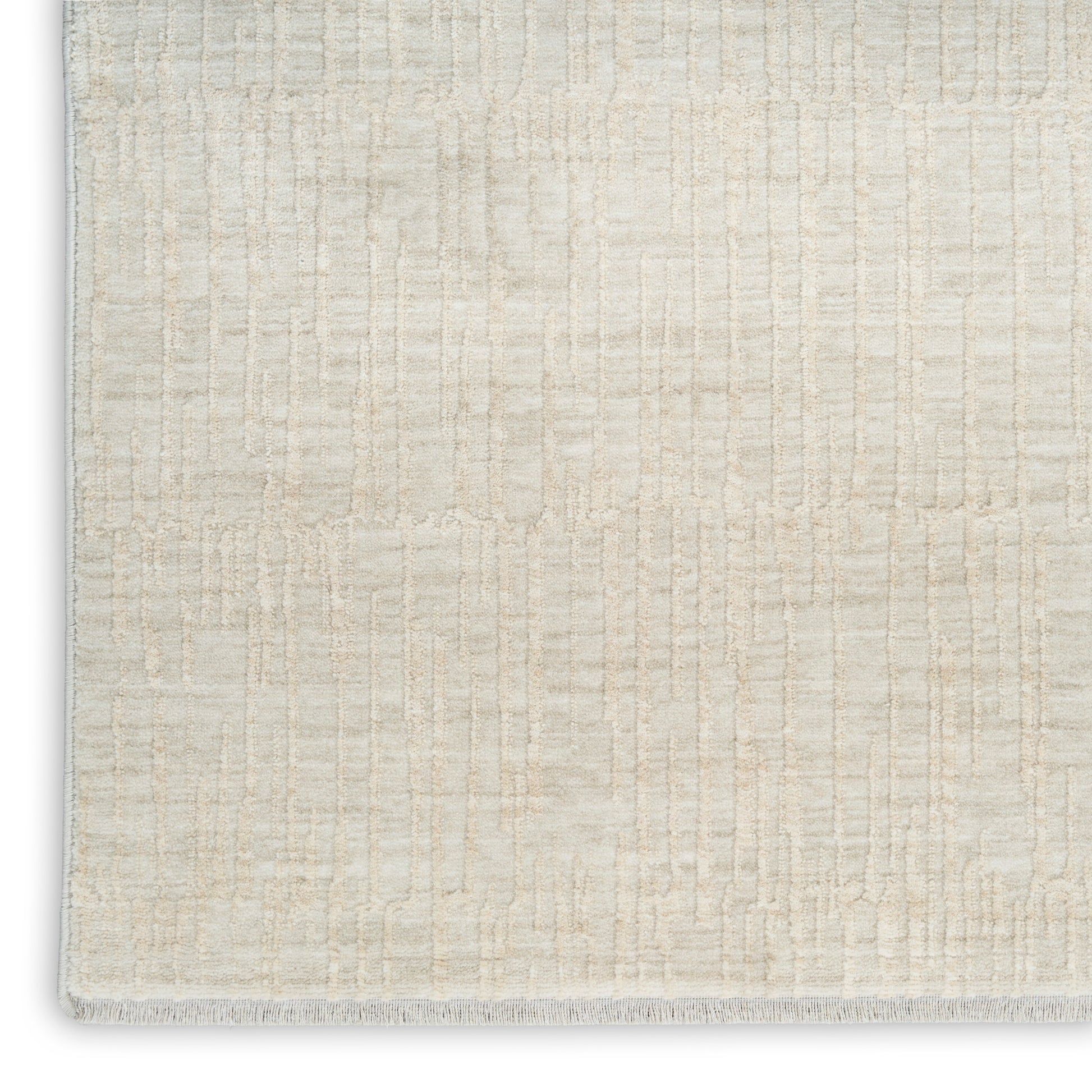 Cream woven area rug with subtle grid texture and a short fringe at the edge.