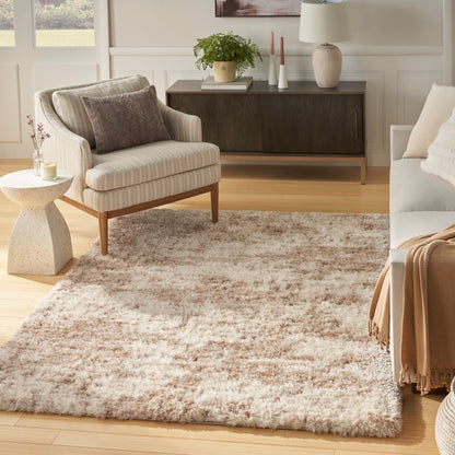 Cream-beige shag rug in a bright contemporary living room with a striped beige armchair, light wood floors and a dark wood console.