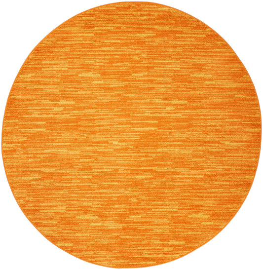 Round orange outdoor rug with subtle striped texture and warm tonal variation.