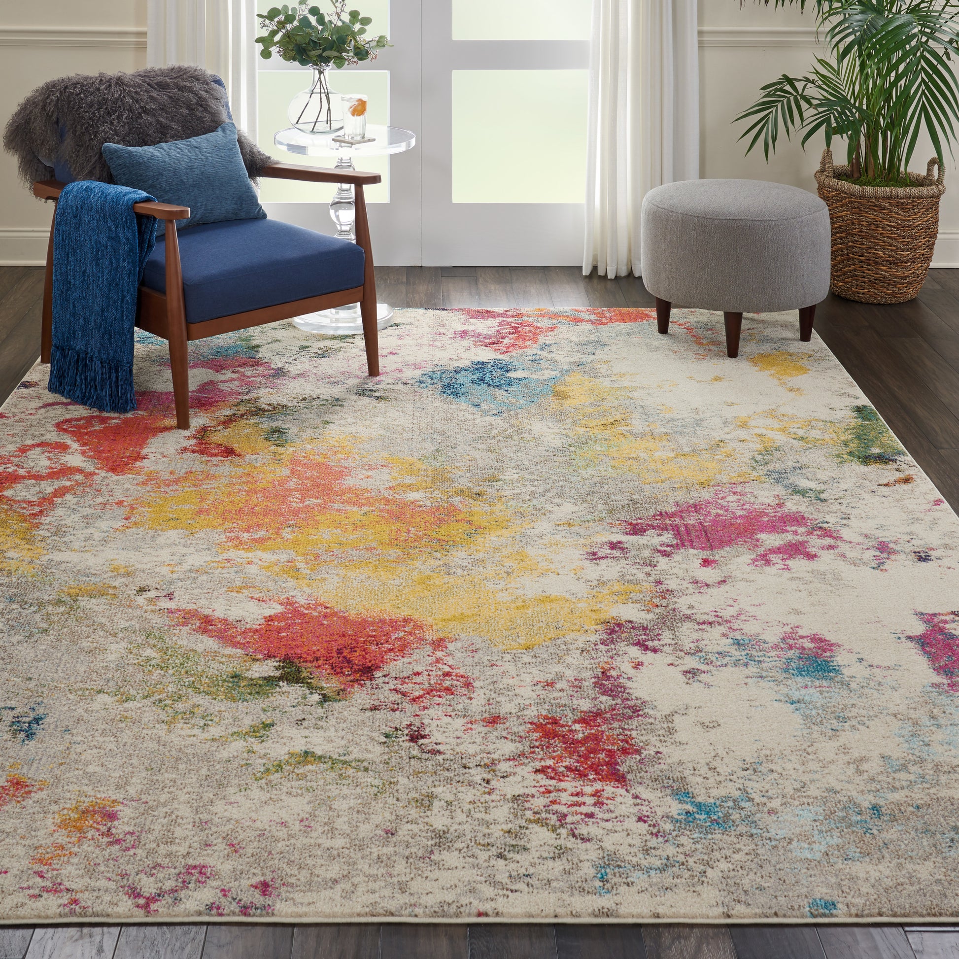 Cozy living room with beige multicolor abstract rug, blue upholstered wooden lounge chair, gray ottoman, and potted plant.