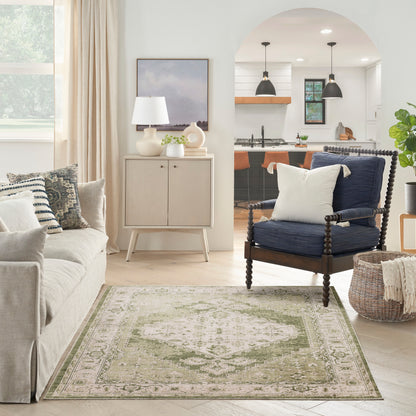 Neutral living room with beige sofa, pale green rug, dark wood spindle chair, light wood cabinet, arched kitchen opening.