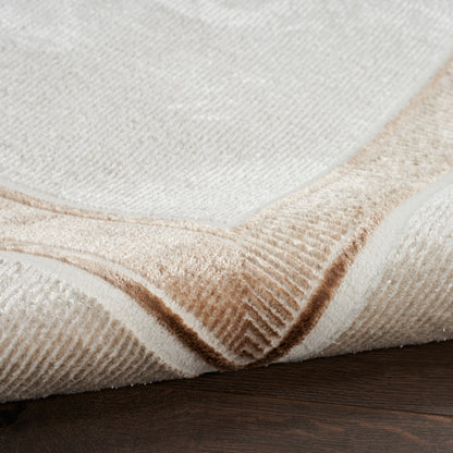 Beige cream rug with tan border, textured loop pile, folded corner on dark wood floor.